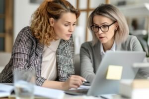 Two women discussing accounting details in a business meeting - symbol of trusted client support at MaLa Accounts